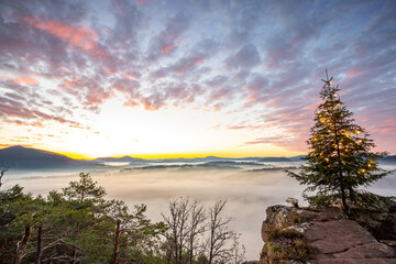 Landscape at sunrise with fog in the valley. View from a cliff in the morning. Beautiful Christmas...
