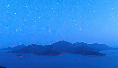 Nighttime view of a group of islands.  Dark silhouettes of mountains and islands rise from a still, deep blue-purple sea, under a star-speckled, light-blue twilight sky