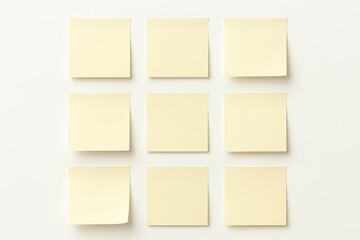 Nine yellow sticky notes arranged on a white surface with soft shadows, concept for reminders organization and brainstorming