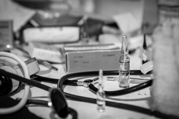 Vintage Medical Ampoule and Stethoscope on a Desk close up monochrome