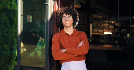 Pub, portrait and waiter with arms crossed at door for friendly welcome, hospitality and waiting....