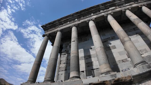 Majestic columns of the Garni Temple in Armenia reaching towards a vibrant blue sky, showcasing the beauty of hellenistic architecture in a historical landmark