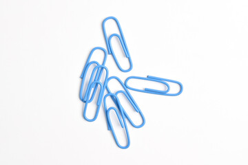 Many blue paper clips isolated on white background