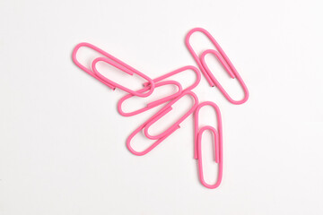 Many pink paper clips isolated on white background