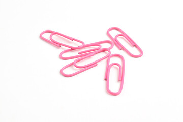 Many pink paper clips isolated on white background