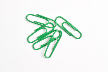 Many green paper clips isolated on white background