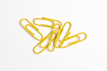 Many yellow paper clips isolated on white background