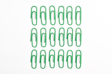 Many green paper clips isolated on white background, flat lay
