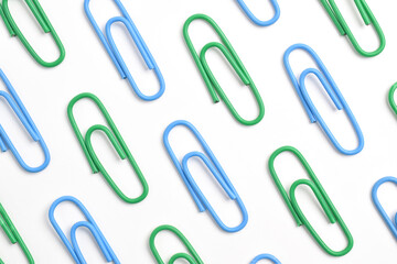Many green and blue paper clips isolated on white background, flat lay