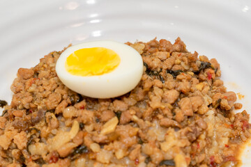 A Thai basil minced pork set meal arranged on a tray, including a portion of stir-fried spicy basil pork, a bowl of steamed white rice, three side vegetables, and a bowl of soup. The presentation refl
