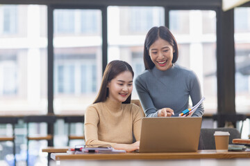 Obraz premium Two Asian young businesswoman using laptop computer working in office,