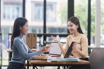 Fototapeta premium Two young Asian businesswoman and looking at digital tablet company device in office. 