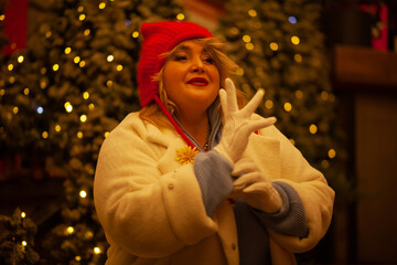 Plus size woman walks around the city during the Christmas of the week with a hot drink in a glass...
