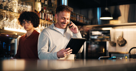 Happy man, bartender and tablet with phone call for online order, stock or inventory in restaurant. Male person, barman or employee with smile on technology or mobile smartphone for alcohol checklist