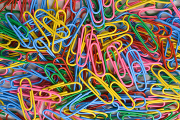 Pile of colorful paper clips on white background, top view