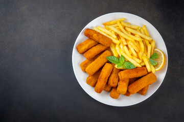 Fish and chips .Close up of crispy breaded deep fried fish fingers with breadcrumbs served with remoulade sauce and lemon
