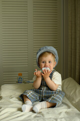 Festively dressed baby sitting on a changing table and playing with a toy at home. Adorable...