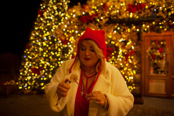 Plus size woman walks around the city during the Christmas of the week with a hot drink in a glass...