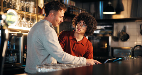 Bar, waiter and teamwork with tech for order, manager and training of employee to review sales data. Pub, server and people with app to process transactions, conversation or help with system at night