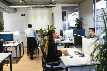 Diverse team collaborating in a bright, open plan office, showcasing modern work culture and inclusivity