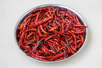 Hot fried red chili peppers on a steel plate, perfect for spicy food. Dry chilies ready for chilli...