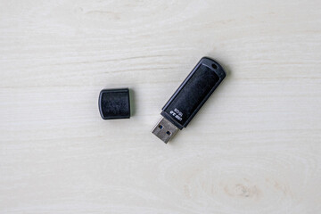 Modern 16GB USB 3.0 Black Pendrive Top Down View on Light Wooden Desk.