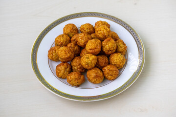 Delicious, crispy fried chicken and spicy meatball platter. Golden brown, savory meal on a wooden surface, perfect for food blogs, recipes, and restaurant menus.