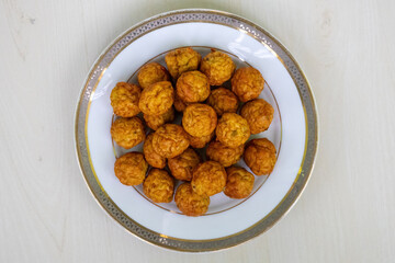 Delicious Spicy Fried Chicken Meatballs on Plate, Light Wood Background, Top View