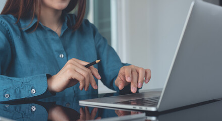 Business woman working on laptop computer at office. Young smart businesswoman surfing the...