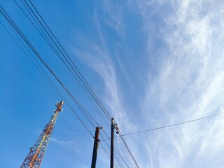 Telecommunication Tower and telephone Lines Against a Clear Blue Sky. fiber optics cable