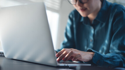 Business woman working, typing on laptop computer at modern office, close up. Freelancer online working from home. Student studying online, surfing the internet, searching the information, e-learning