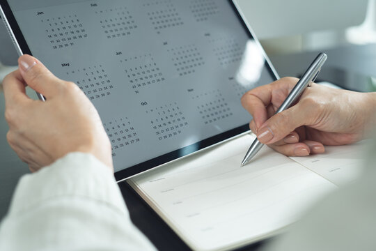 2026 Calendar event planner timetable agenda plan on organize schedule. Business woman using digital tablet with monthly calendar for event planning, Plan scheduling, writing on notebook at office