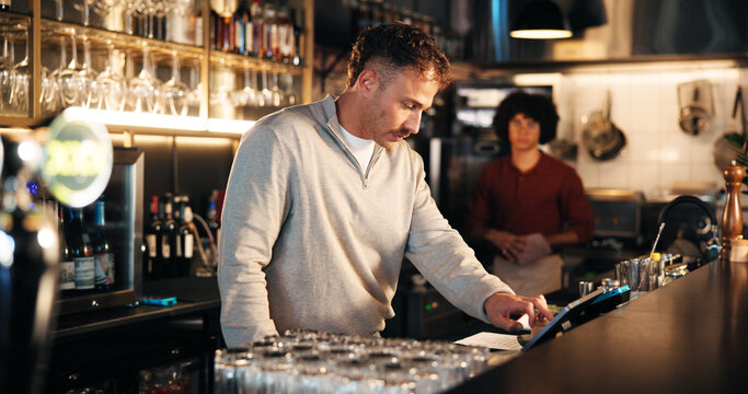 Bartender, manager and tablet at pub for POS, inventory checklist and inspection for small business service. People, bar man and digital technology with app for menu, feedback or hospitality review