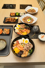 A hearty bowl of seafood noodle soup filled with shrimp, corn, egg, vegetables, rice blood cake, tofu skin, and assorted hotpot ingredients. The colorful ingredients float in a rich broth, making for 