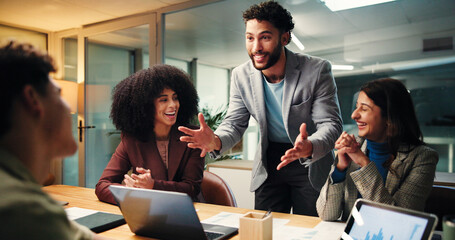 Business, people and applause in office at night for good news, celebration and finance growth. Staff, laptop and clapping hands for team success, deadline achievement and feedback on investment deal