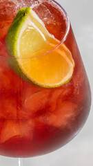 Chilled scarlet spritz crowned with tangy citrus, reminiscent of Carnivale revelry, sipping...