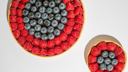 Two symphonic berry tarts bask in sunlight, evoking Midsummer's fruit bounty and the joyous revelry...
