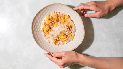 <p style=text-align:left;>Nurturing hands cradle pineapple-infused granola over rice pudding,...