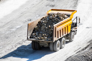 Heavy-duty dump truck brimming with rugged earth treasures, echoing the industrious spirit of...
