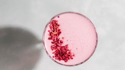 Creamy rose-hued smoothie crowned with ruby shards, whispering of midsummer solstice magic and Ayurveda healing rituals