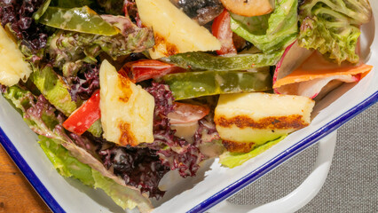 Grilled halloumi nestles amidst verdant lettuce, invoking Cypriot harvest festivals and midsummer garden feasts, with vibrant radicchio whispers