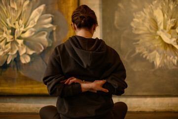 Young woman practicing yoga poses in an art gallery space, combining wellness and creativity. Mindful lifestyle, body awareness, and harmony in modern cultural environment
