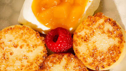 Golden-crisp syrniki with dollop of peachy delight and raspberry, evoking Maslenitsa brunch, Slavic...