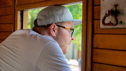Sunlit reflection of contemplative Caucasian man in cap on train evokes wanderlust, Chuseoks...