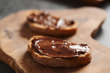 Ciabatta slices with chocolate spread on olive wood board