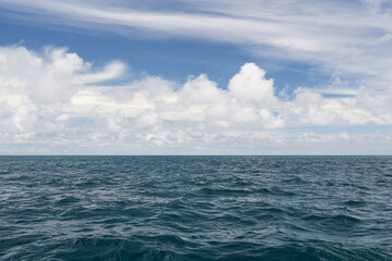 Obraz premium Ocean waves with turquoise water and white clouds