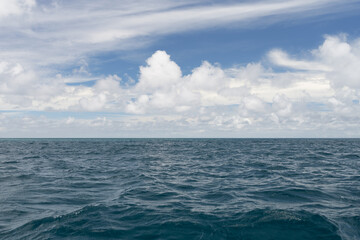 Fototapeta premium Ocean waves with turquoise water and white clouds