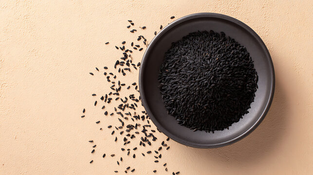Black cumin seeds in a dark bowl overhead view nigella seeds