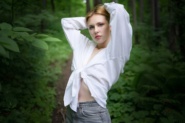 Young and pretty blonde woman in the forest.