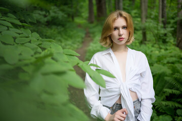 Young and pretty blonde woman in the forest.